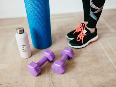 Set of light dumbbells and a yoga mat in a modern room